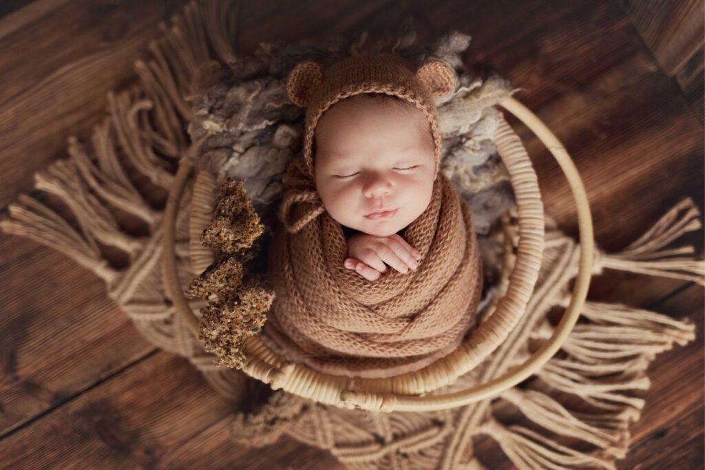 På billedet ses en baby i svøb i et babytæppe. Billedet bruges til en Informativ blogindlæg om alt du skal vide om babytæppe.